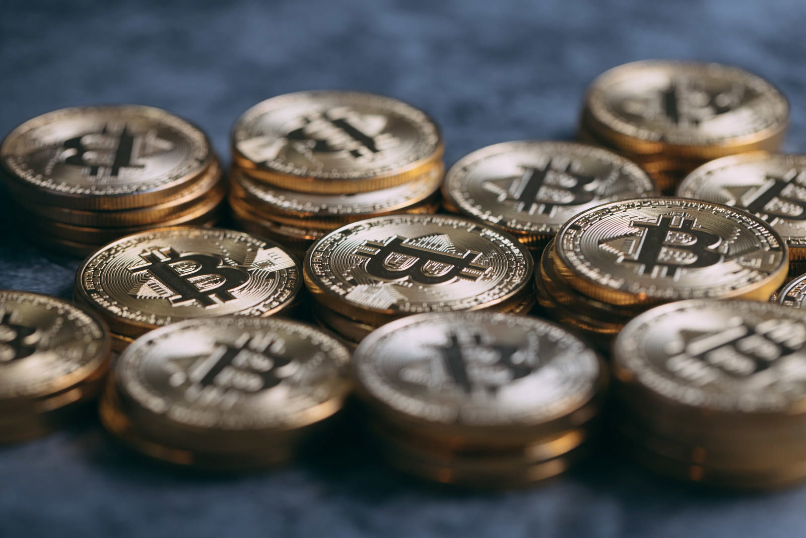 金色に輝く複数のビットコインが重なって配置された写真