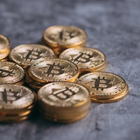 一ヵ所に集められた金色のビットコインの山の写真