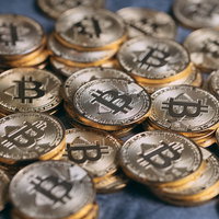 金色に輝く複数のビットコインが重なり散らばるの写真