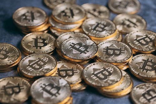 金色に輝く複数のビットコインが重なり散らばる