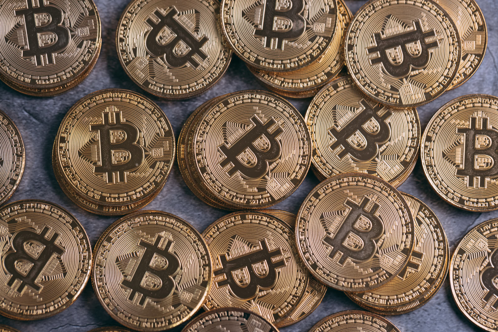 金色に輝くビットコインが複数枚積み重なっている様子