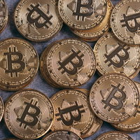 積み重なったビットコインと金貨のコインの写真
