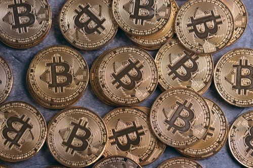 積み重なったビットコインと金貨のコイン