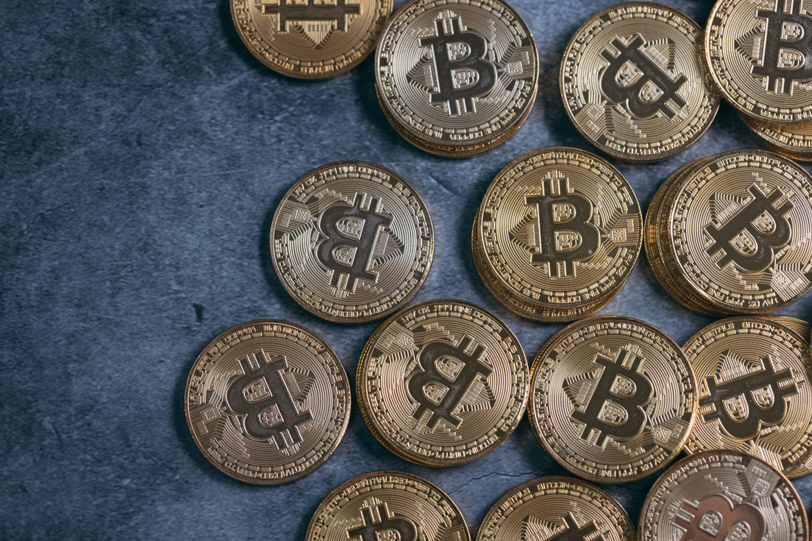 青い背景に配置された金色のビットコインのコイン