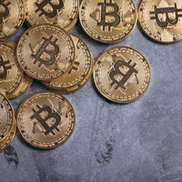 グレーの背景に無造作に置かれたビットコインの写真