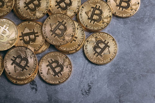 デジタルゴールド、ビットコインコインが青いテーブルに散らばる