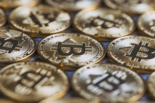 光に輝くビットコインと金貨の投資