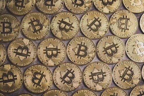 卓上に敷き詰めたビットコイン、金色に輝くコイン