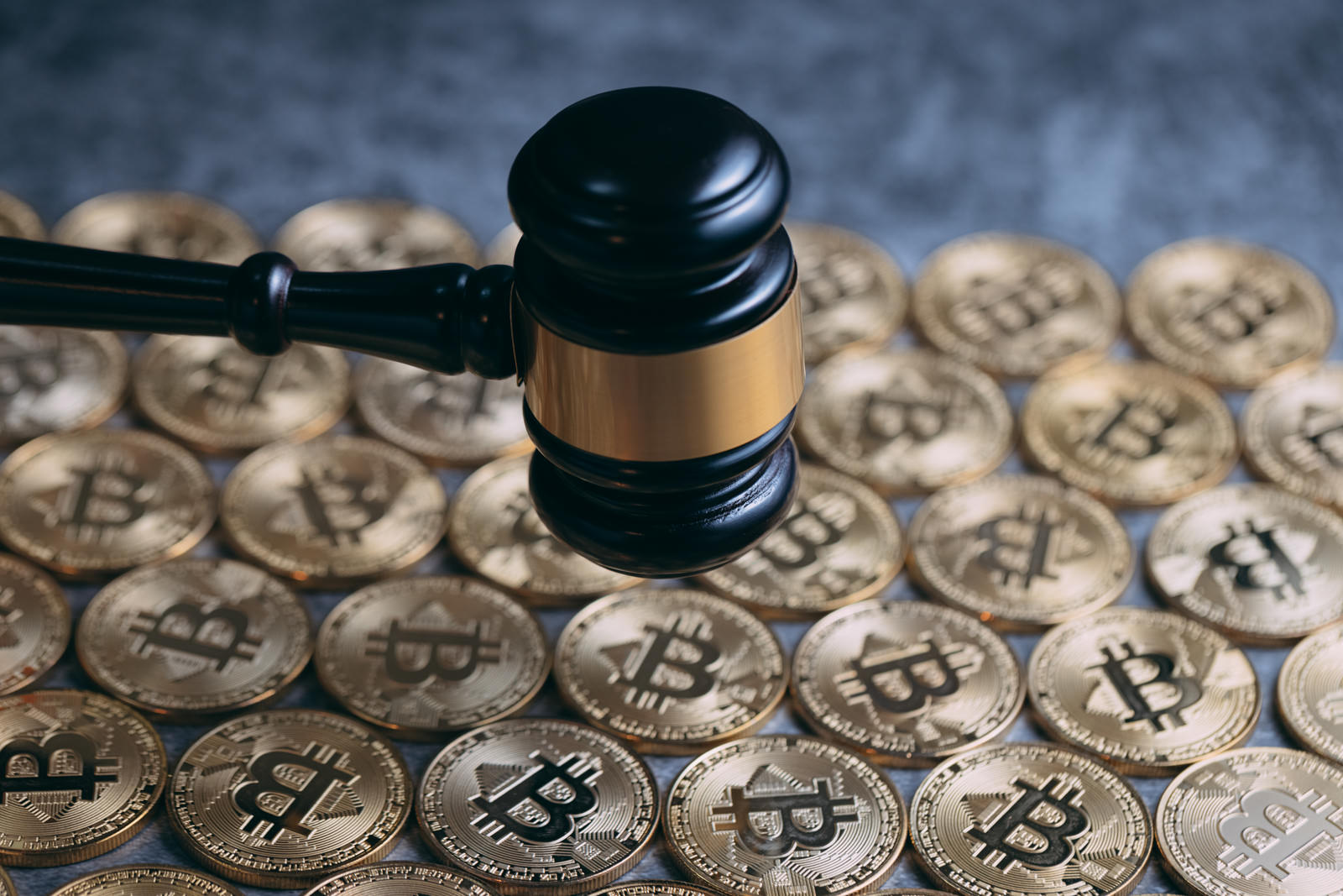 木製のガベルと金色のビットコインコインが並んだ法的イメージ
