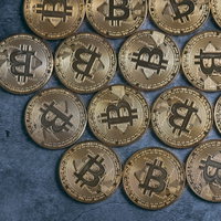 青いテクスチャ背景に右寄せで並べたビットコインの写真