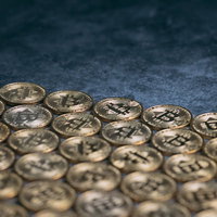 床に規則正しく整列させたビットコインの金貨の写真