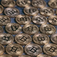 床を無造作に埋め尽くす金色のビットコインの写真