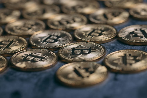 卓上に散らばるビットコインの金貨、投資と仮想通貨の概念表現