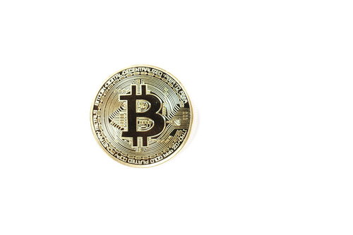 白い背景に置かれたゴールドカラーのビットコイン1枚
