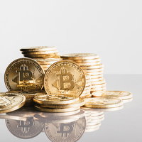 ビットコインと金色コインが積み重なるバブルの写真