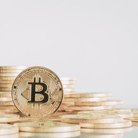 溢れるビットコインのコインと金融投資の積み重ねの写真