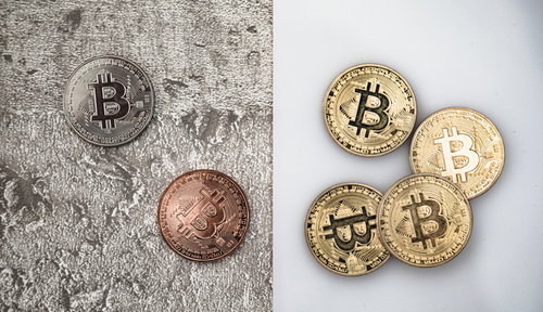 命運が分かれるビットコイン、砂に埋もれたコインと輝く金銀色のコイン