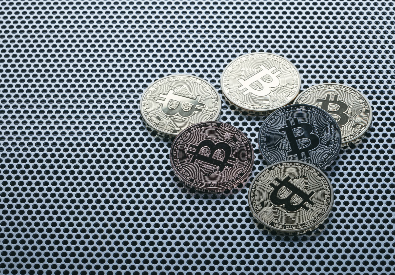 シルバーとゴールドの異なる色合いのビットコインコインが並んでいる
