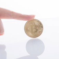 はじめてのビットコイン投資で人差し指が指し示すゴールドコインの写真