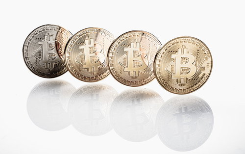 白い背景に並ぶビットコイン4枚の金色のコイン