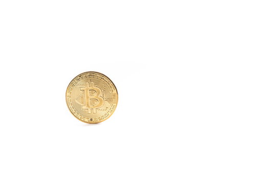 白い背景に置かれた金色のビットコインコイン