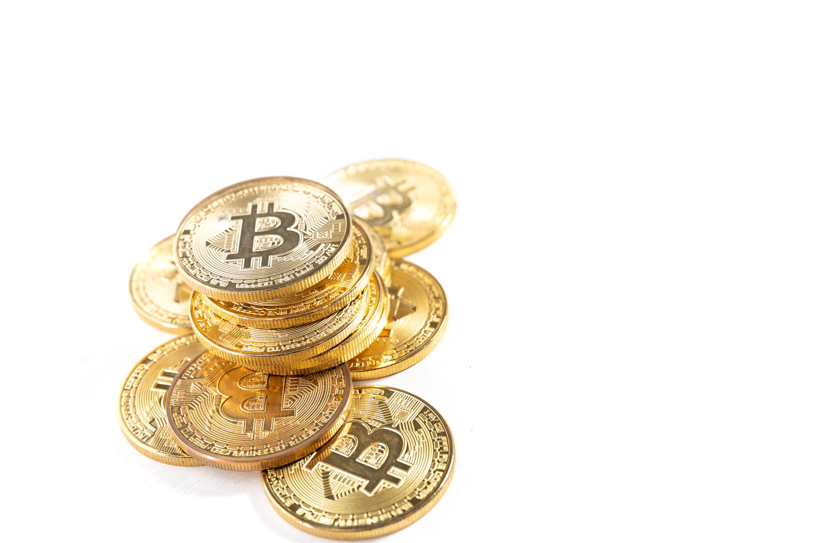 金色に輝く複数のビットコインが積み重なっている様子