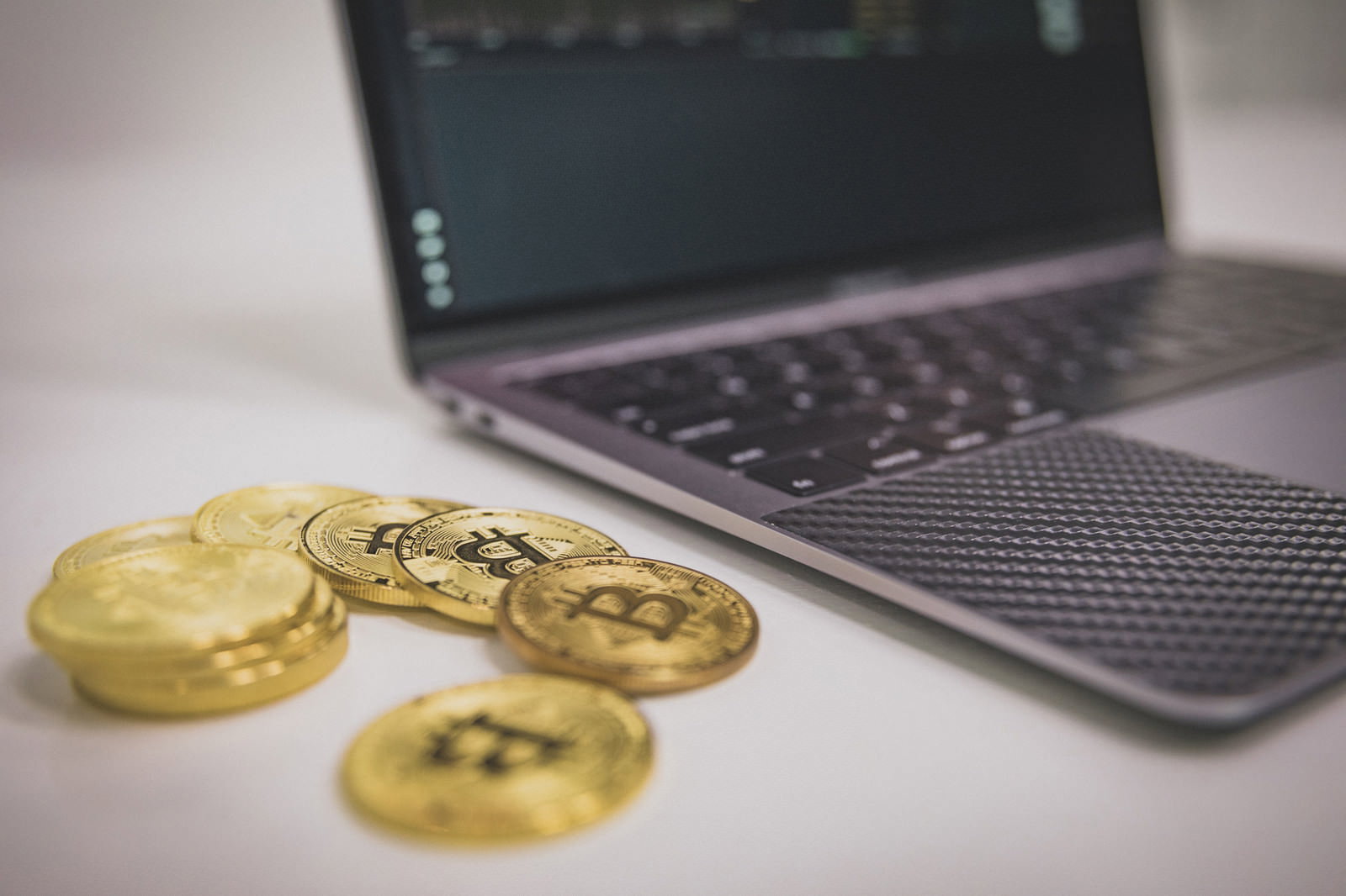 デスクの上に置かれたビットコインとノートパソコン