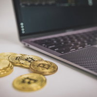 デスクでビットコインの電子売買とノートパソコンの写真