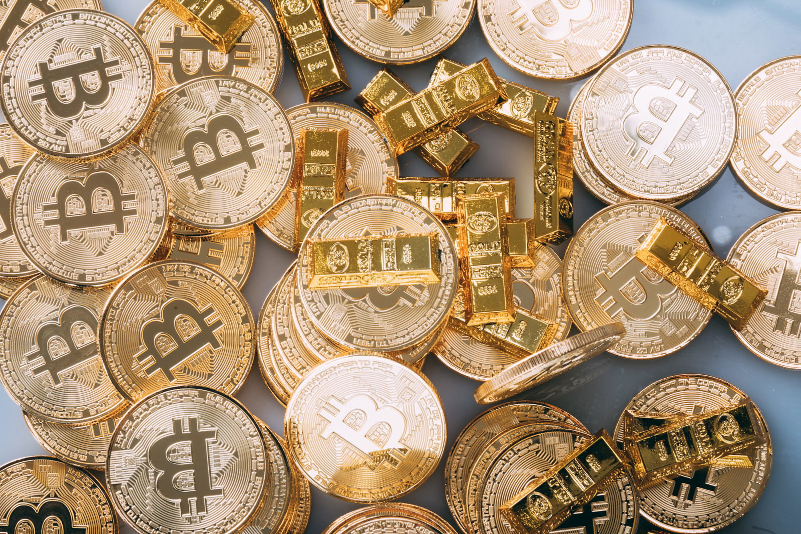 金色に輝く多数のビットコインコインが重なり合って配置された様子