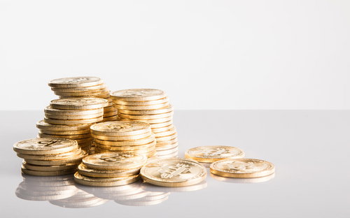 平積みビットコインをつかむ手