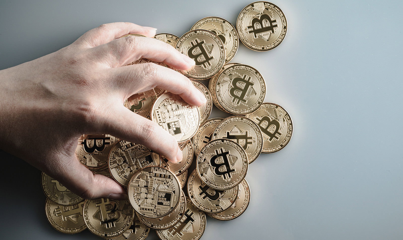 手のひらでビットコインのコインを複数握っている様子