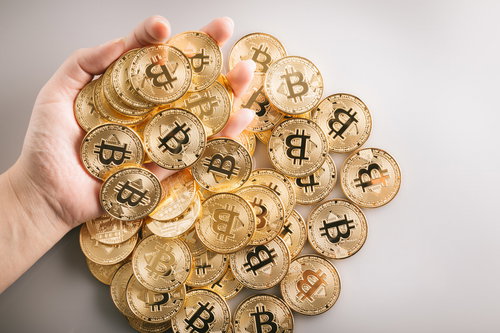 大量のビットコインをガチHOLDする両手の姿