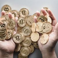 両手いっぱいに広がるビットコイン長者のコインの写真