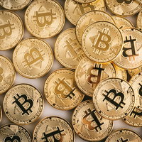 ビットコイン（暗号資産）がじゃぶじゃぶと積み重なった金貨の写真