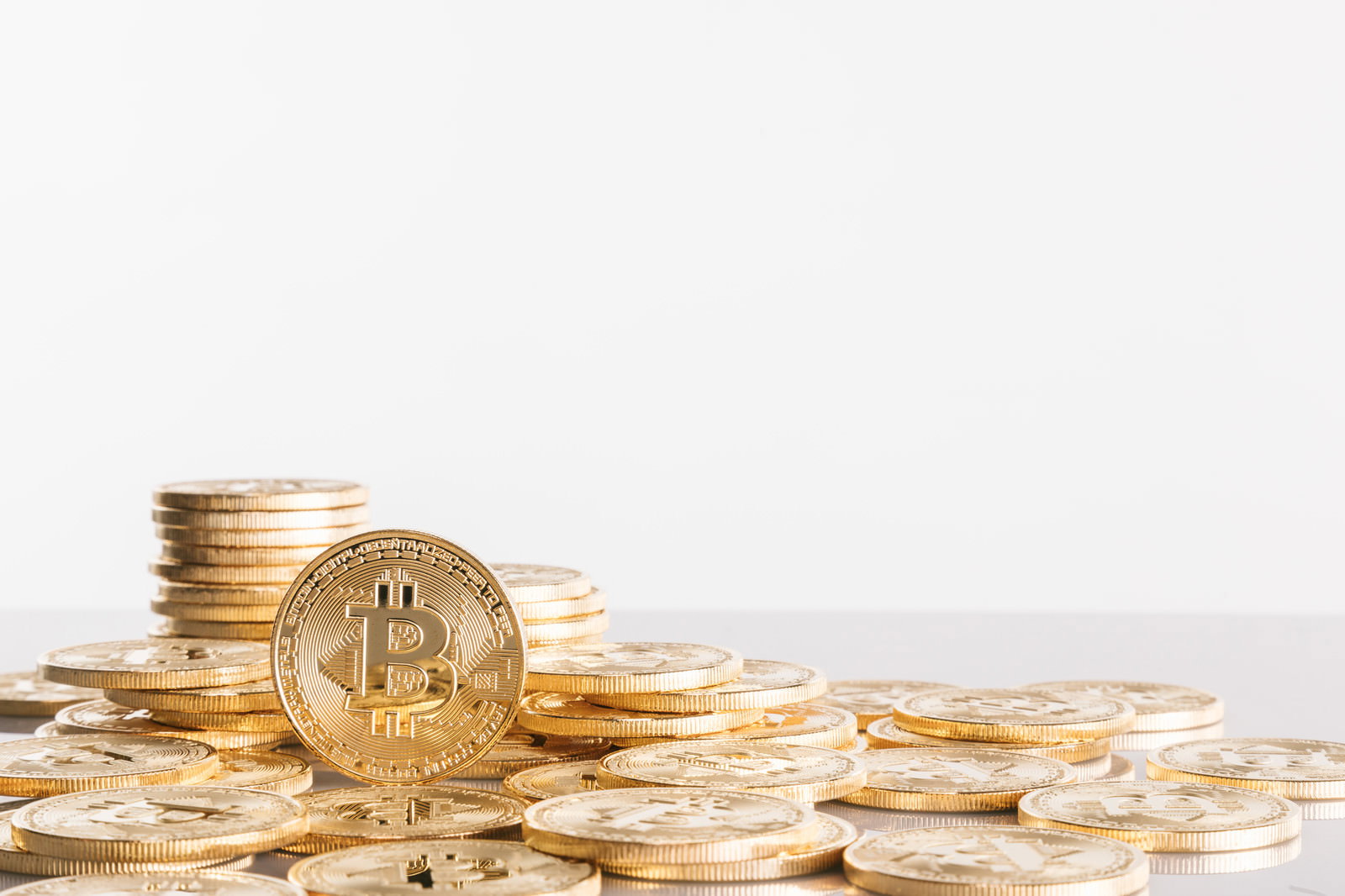 光沢のある金色のビットコインの金貨が複数枚重なった様子