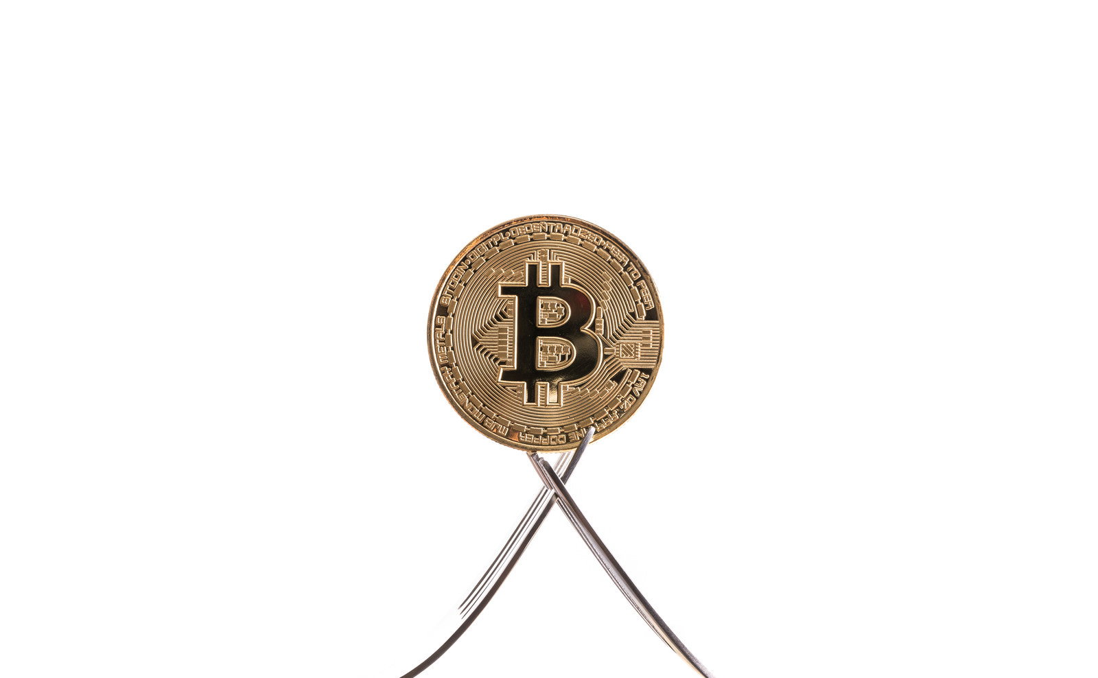 2本のフォークに挟まれた金色のビットコインコイン
