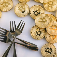 ビットコインと複数のフォークが並べられたハードフォークの概念表現の写真