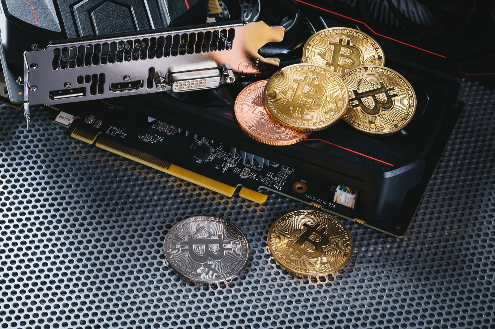 黒いメッシュ素材の上に配置されたグラフィックボードと金色のビットコイン