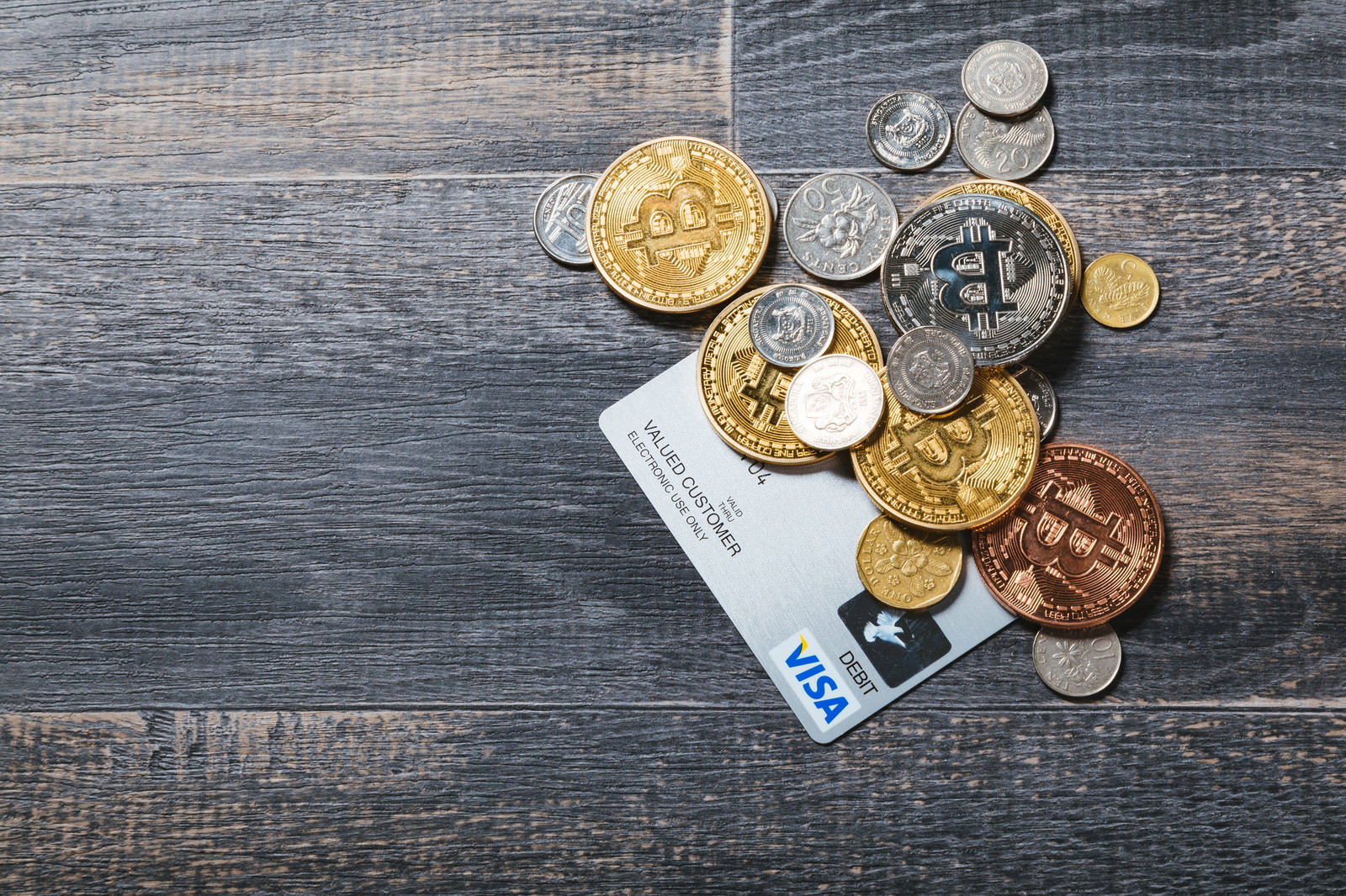 木製テーブルに置かれた仮想通貨コインと紙幣とクレジットカード