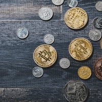 ビットコインとシンガポールドルのコインが散らばるテーブルの写真
