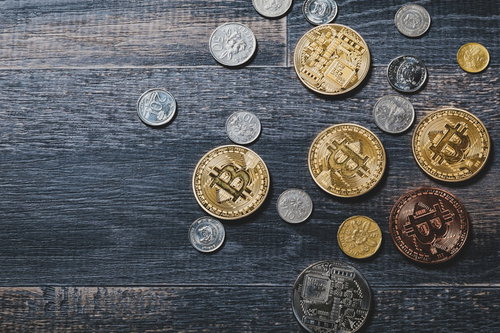 ビットコインとシンガポールドルのコインが散らばるテーブル