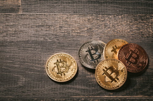 木目調の背景に置かれたビットコイン（BTC）の金色コイン