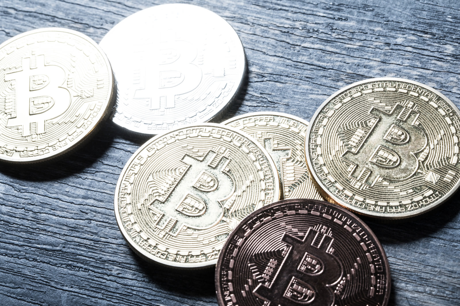 木製テーブルの上に置かれた複数のビットコインコイン