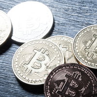 木製テーブルに置かれたビットコインコインの写真