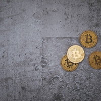 冷たいコンクリート面に置かれた金色のビットコインの写真