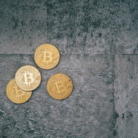 仮想通貨への不安視、コンクリート上に置かれたビットコインの写真