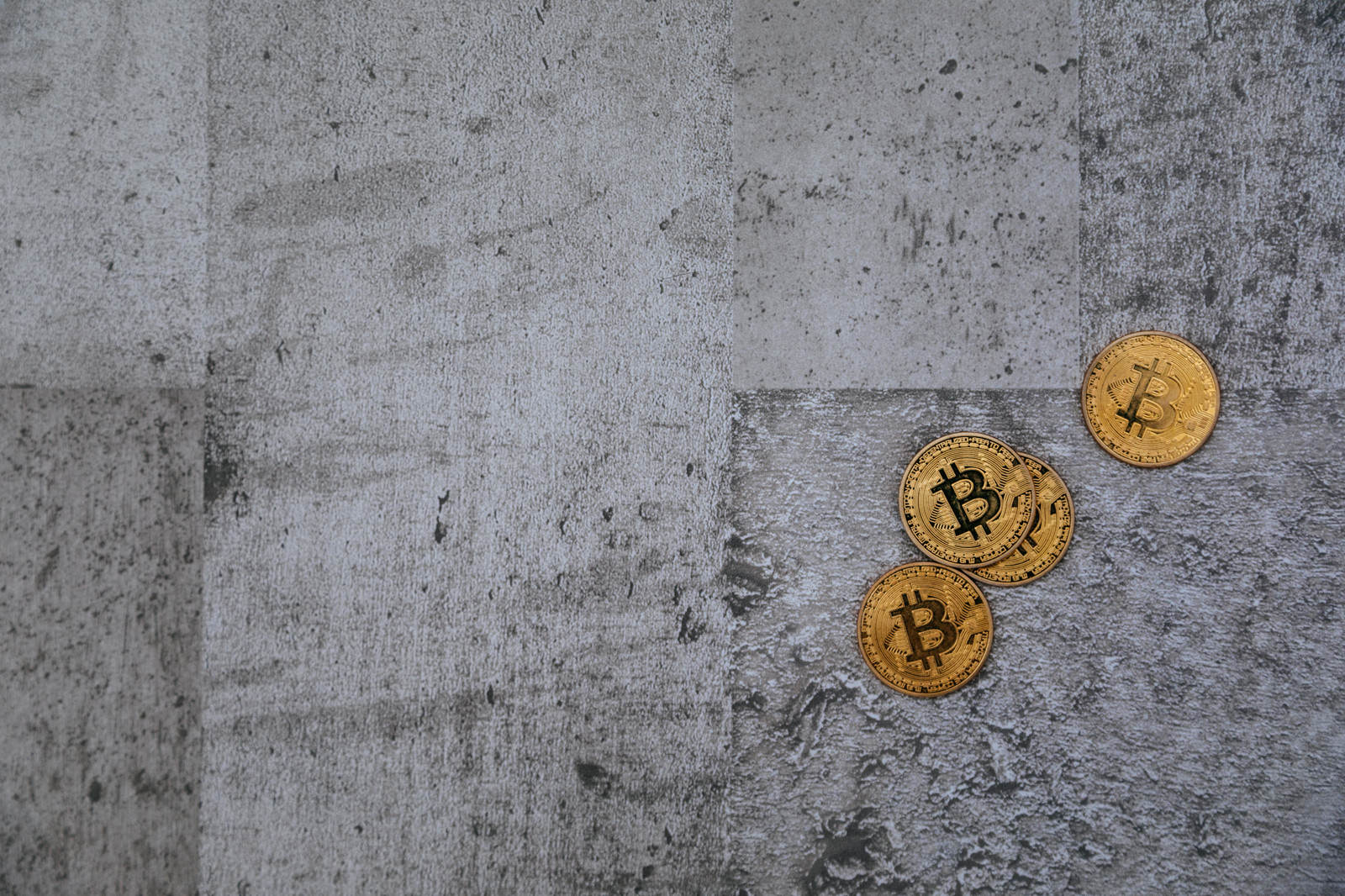 コンクリートに散らばるビットコインとハンマー