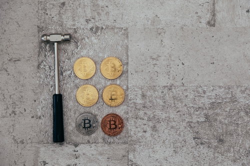 ハンマーで採掘したビットコイン仮想通貨のコンセプト