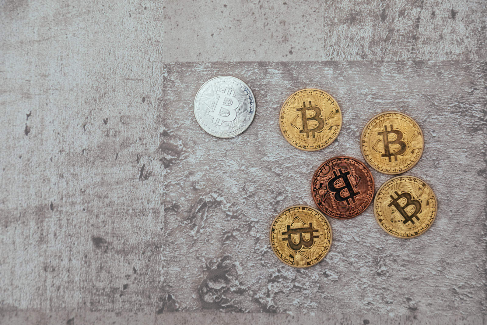 コンクリート面に置かれた金色と銀色のビットコイン硬貨