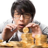 ビットコイン暴落で金貨を手に不安な表情の投資家の写真
